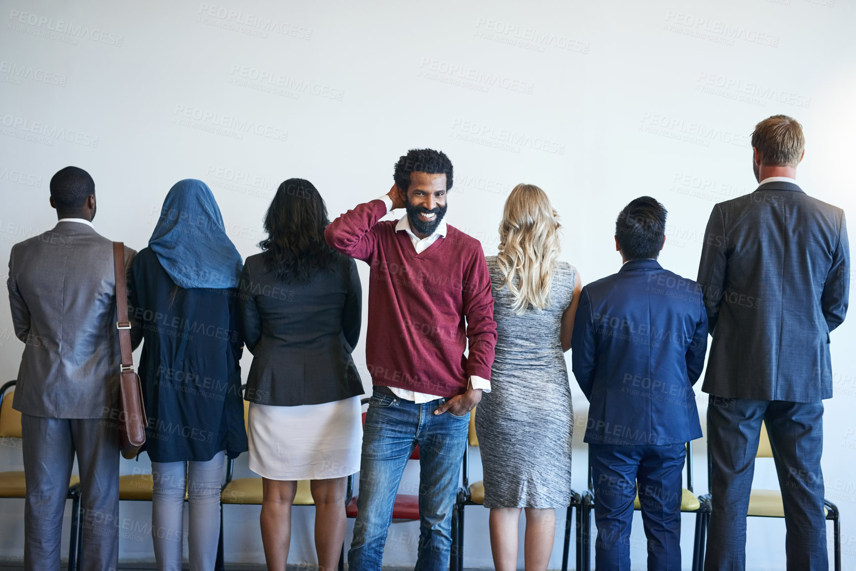 Buy stock photo Portrait of a happy job applicant standing in line with a group of unidentifiable businesspeople