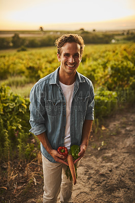 Buy stock photo Shot of a young farmer joking around and being silly with his vegetables