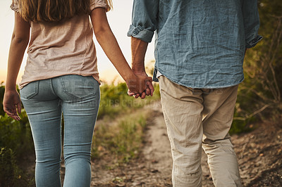 Buy stock photo Unrecognizable shot of a couple walking through their crops while holding hands