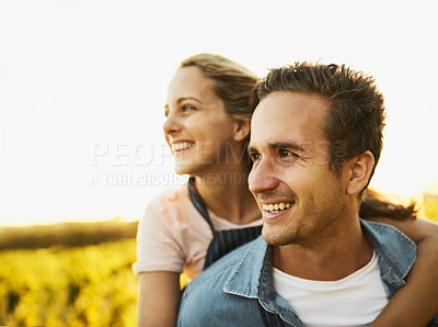 Buy stock photo Shot of a young couple staring at their farmland while holding each other and smiling all the way