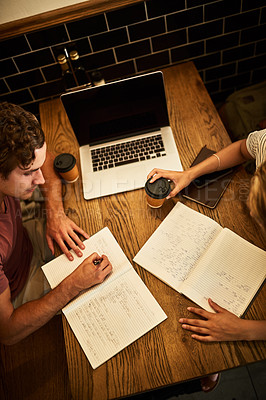 Buy stock photo High angle shot of two unidentifiable students having a study session at a cafe table