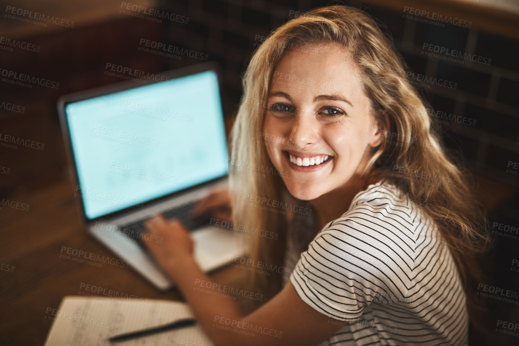 Buy stock photo Portrait of a happy young student using her laptop to study at a cafe table