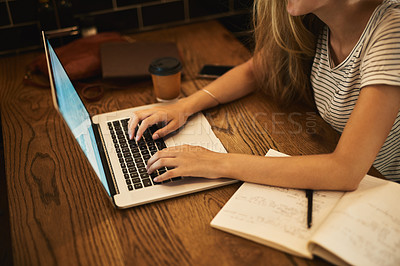 Buy stock photo Shot of an unidentifiable young student using her laptop to study at a cafe table