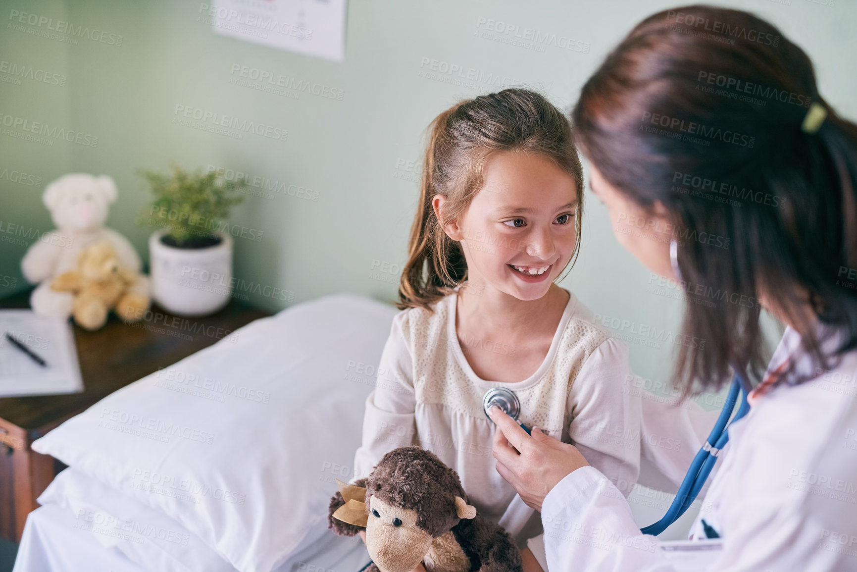 Buy stock photo Healthcare, kids and a girl at a woman pediatrician for an appointment or checkup in the hospital. Medical, stethoscope and cardiology with an adorable female child sitting on a bed in the clinic