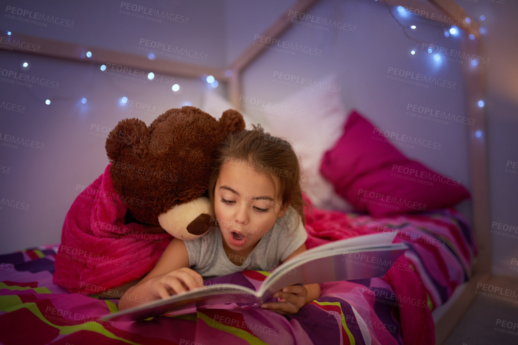 Buy stock photo Cropped shot of a little girl reading a book in bed with her teddybear