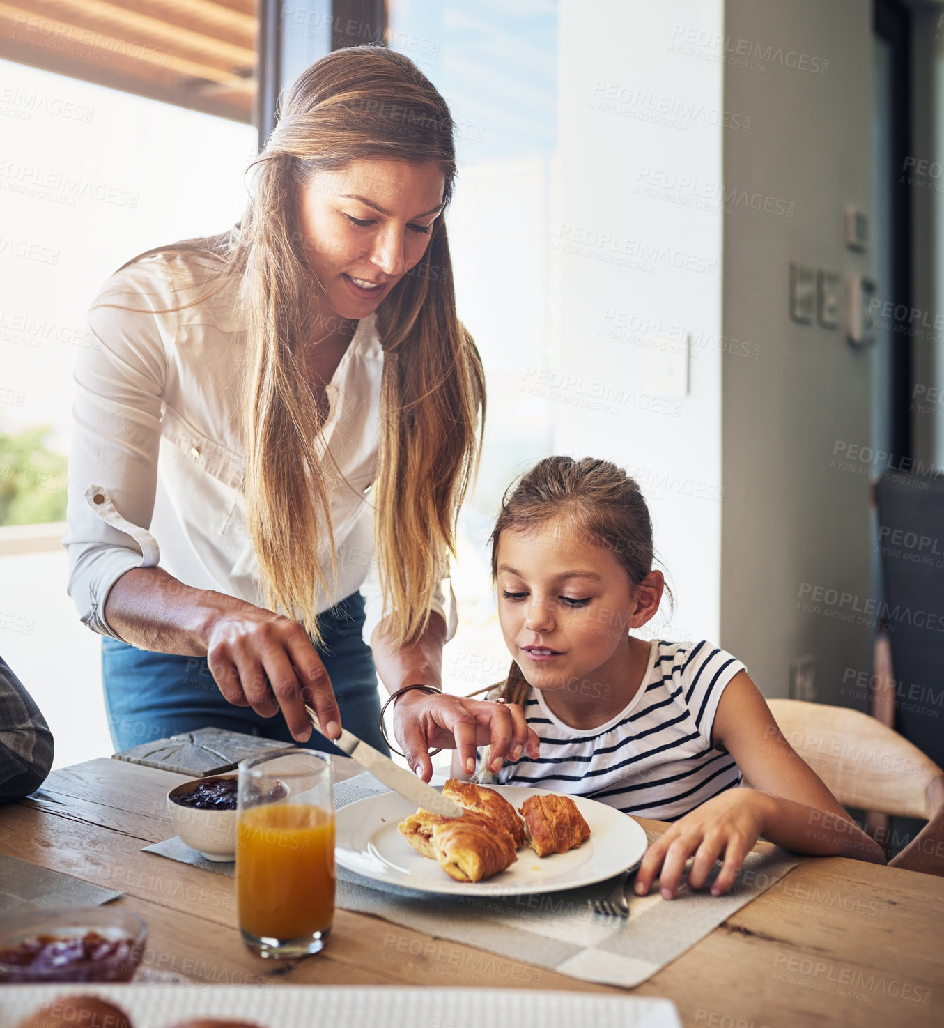 Buy stock photo Shot of a mother having breakfast with her little daughter at home