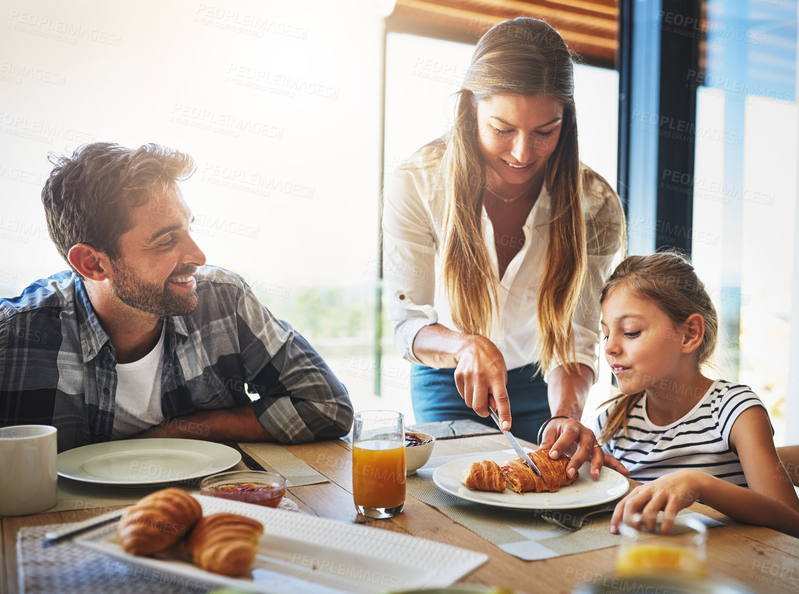 Buy stock photo Family, breakfast and morning in house with cereal, juice and fruit for health or nutrition by table. Woman, knife and help together in home with food for wellness, brunch and bonding with mom help