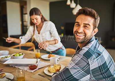 Buy stock photo Portrait of a man having breakfast with his wife in the background