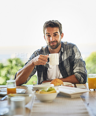 Buy stock photo Portrait of a handsome young man having breakfast at home