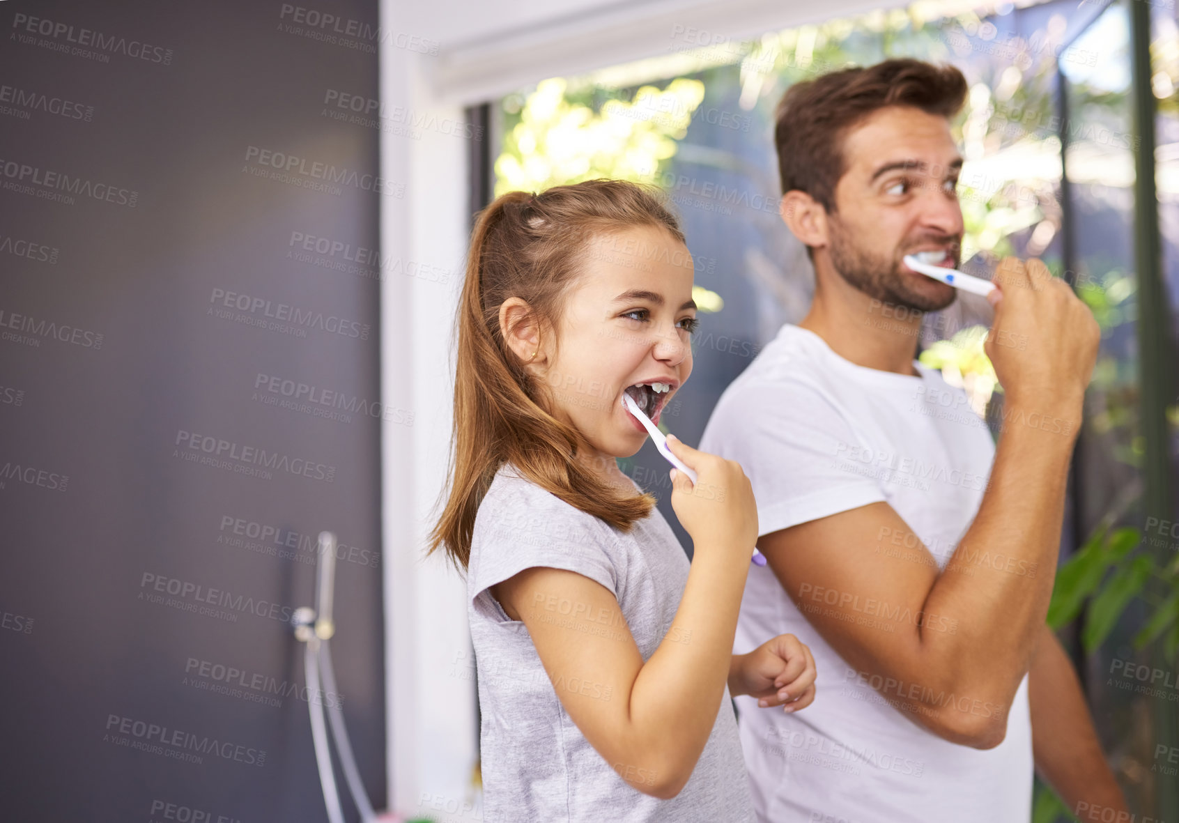 Buy stock photo Cropped shot of a handsome Dad and his daughter brushing their teeth in the bathroom at home