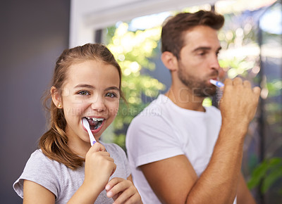 Buy stock photo Cropped shot of a handsome Dad and his daughter brushing their teeth in the bathroom at home