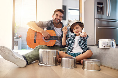 Buy stock photo Portrait of a happy father accompanying his young son on the guitar while he drums on a set of cooking pots