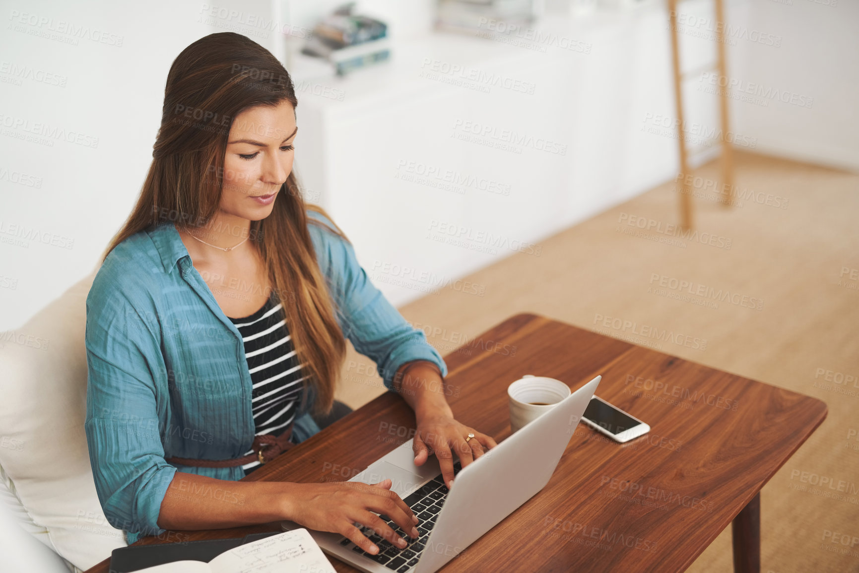 Buy stock photo Shot of a focussed freelancer using her laptop while working from her office at home