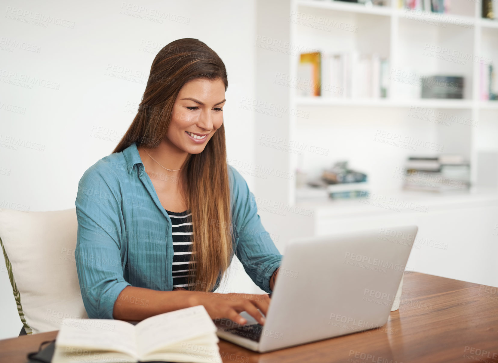 Buy stock photo Shot of a happy freelancer using her laptop while working from her office at home