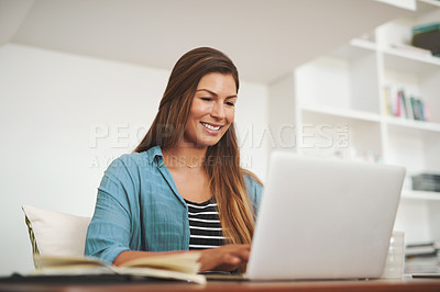 Buy stock photo Shot of a happy freelancer using her laptop while working from her office at home