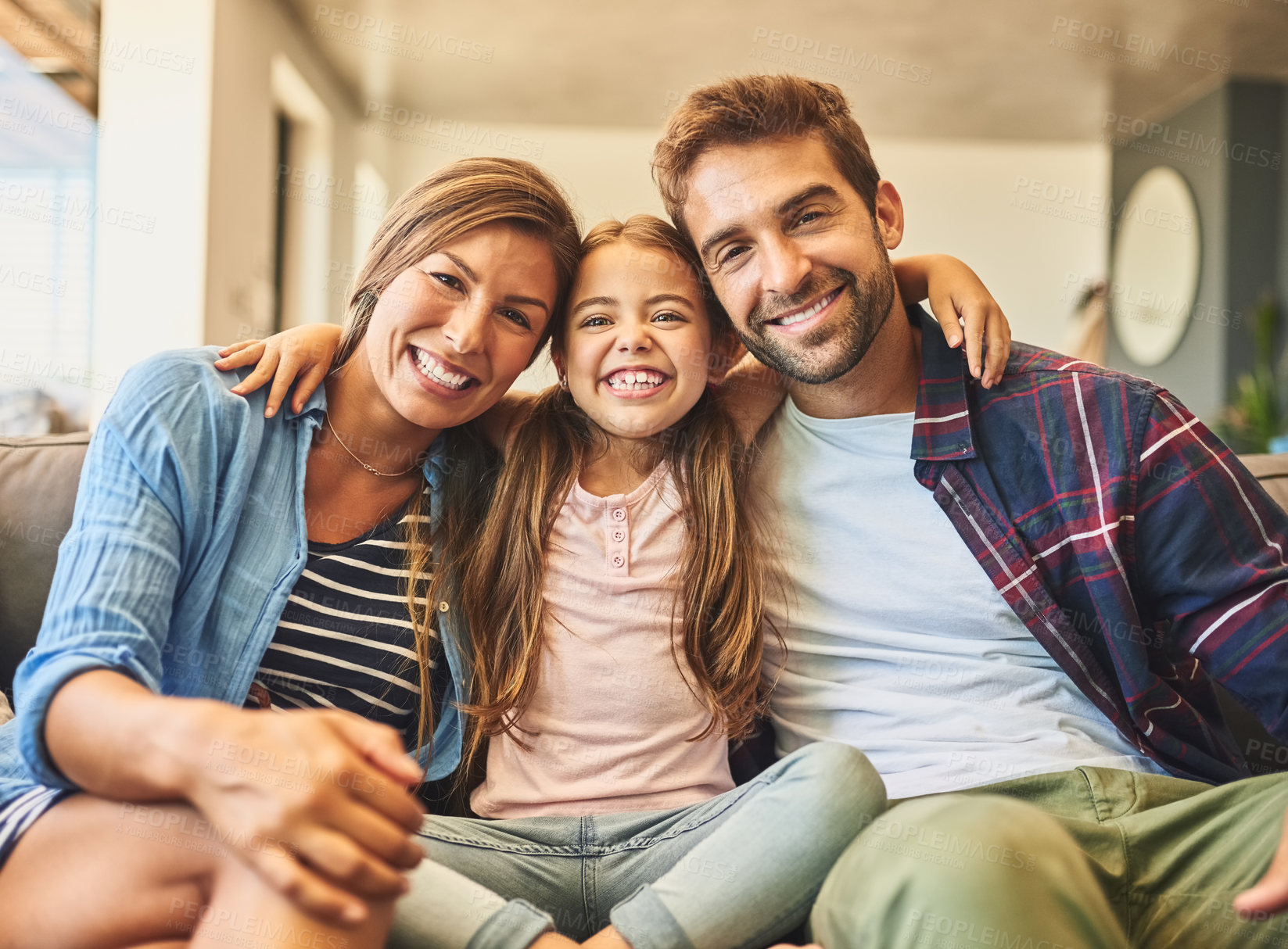 Buy stock photo Shot of a happy family of three relaxing together on the sofa at home