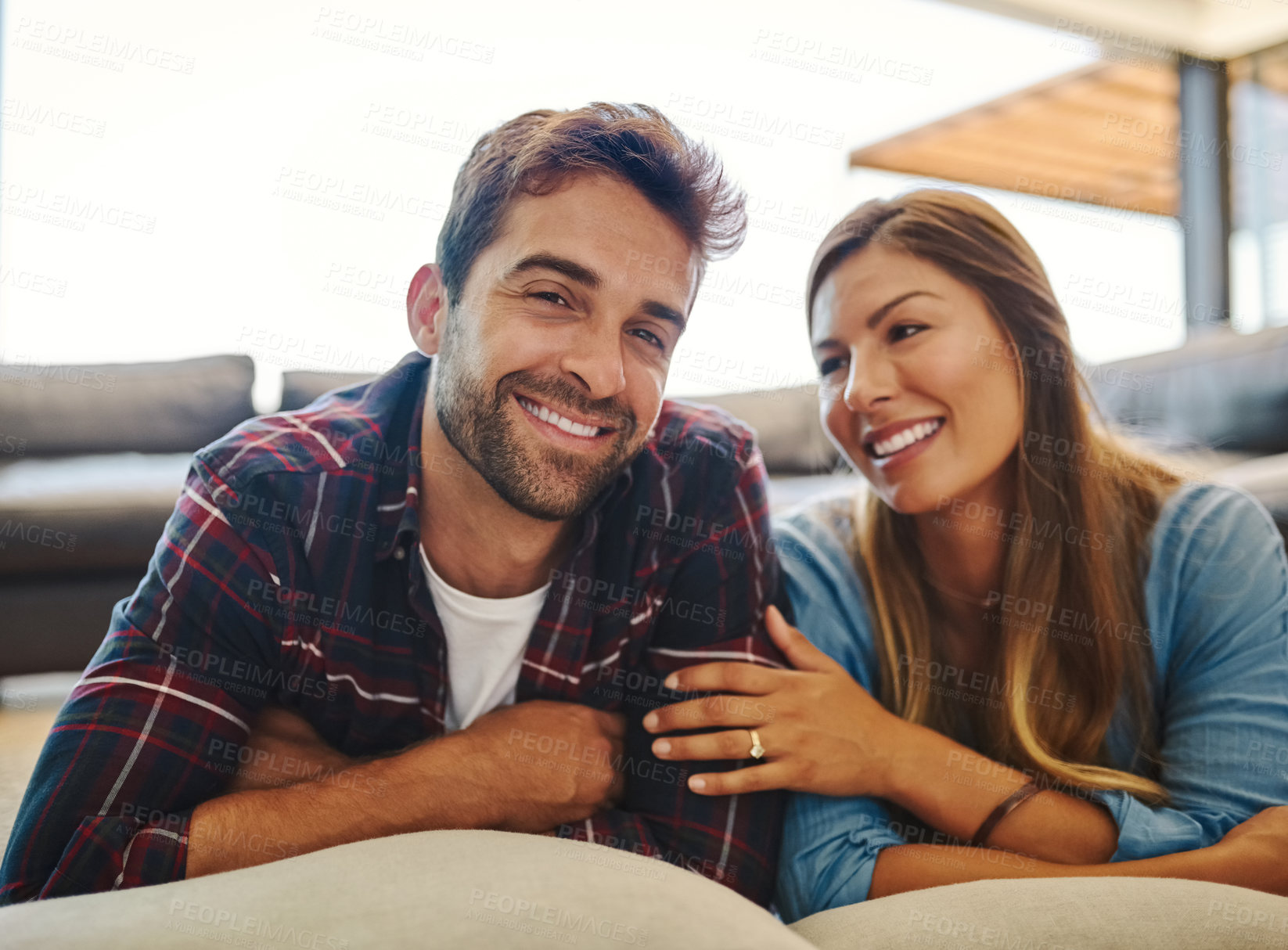 Buy stock photo Portrait of a happy young couple relaxing together on their living room floor