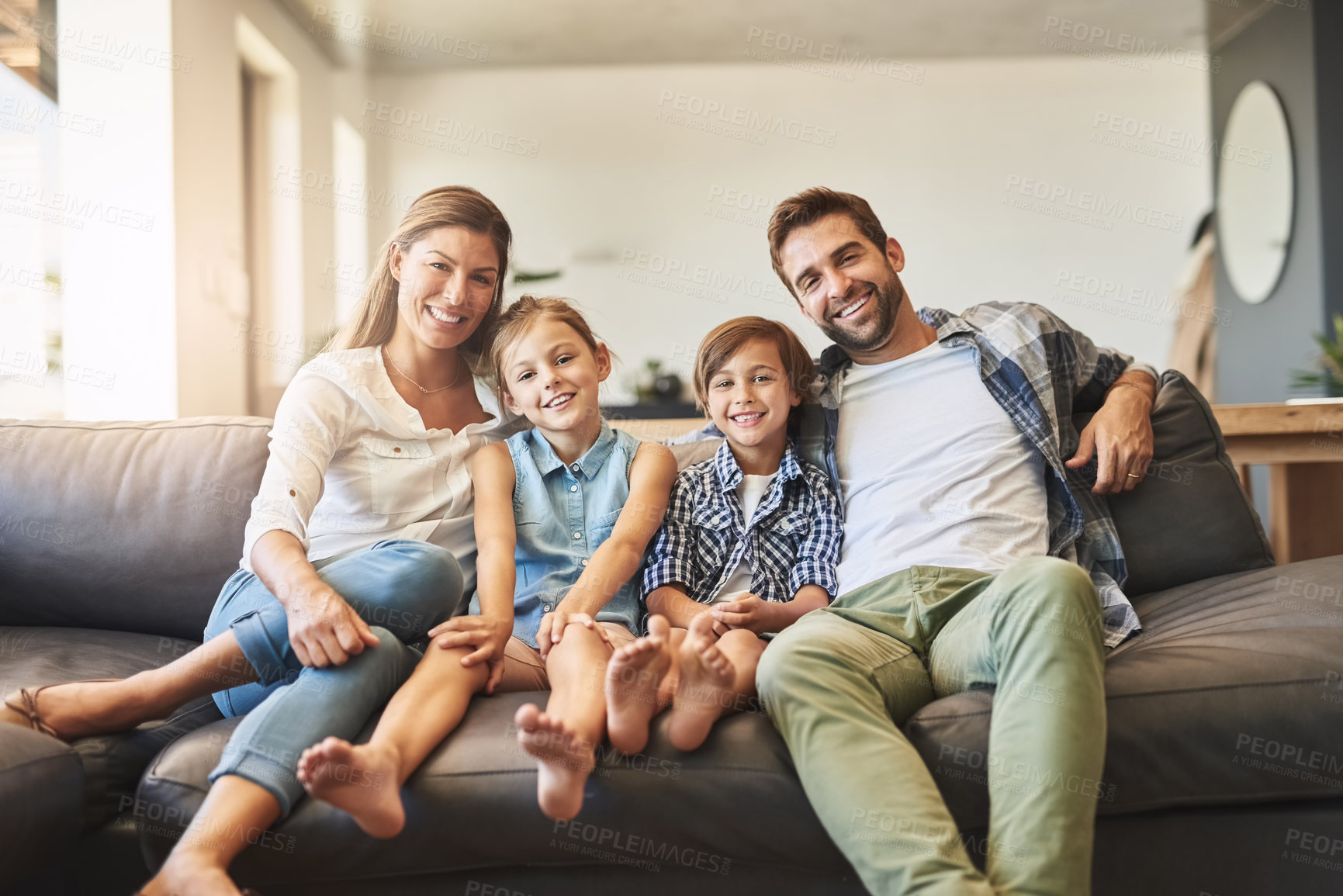 Buy stock photo Shot of a happy family of four relaxing together on the sofa at home