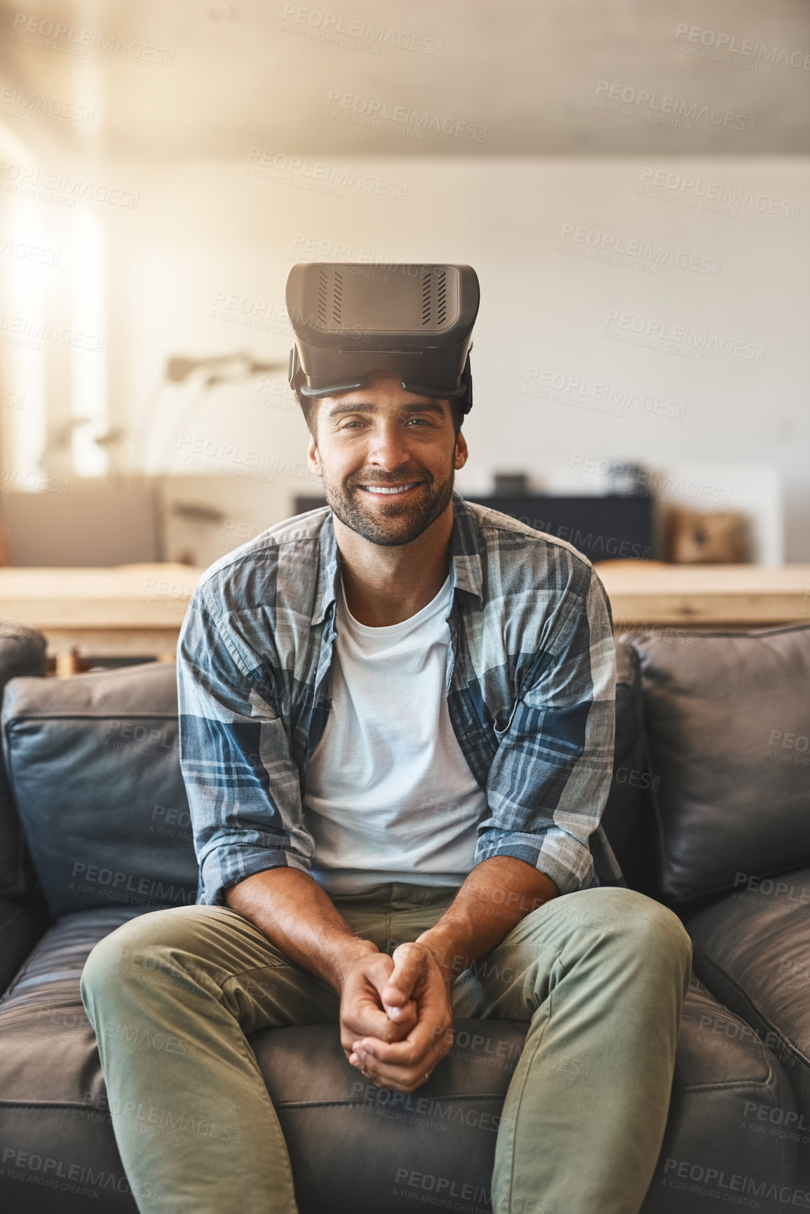 Buy stock photo Shot of a young man using a virtual reality headset on the sofa at home