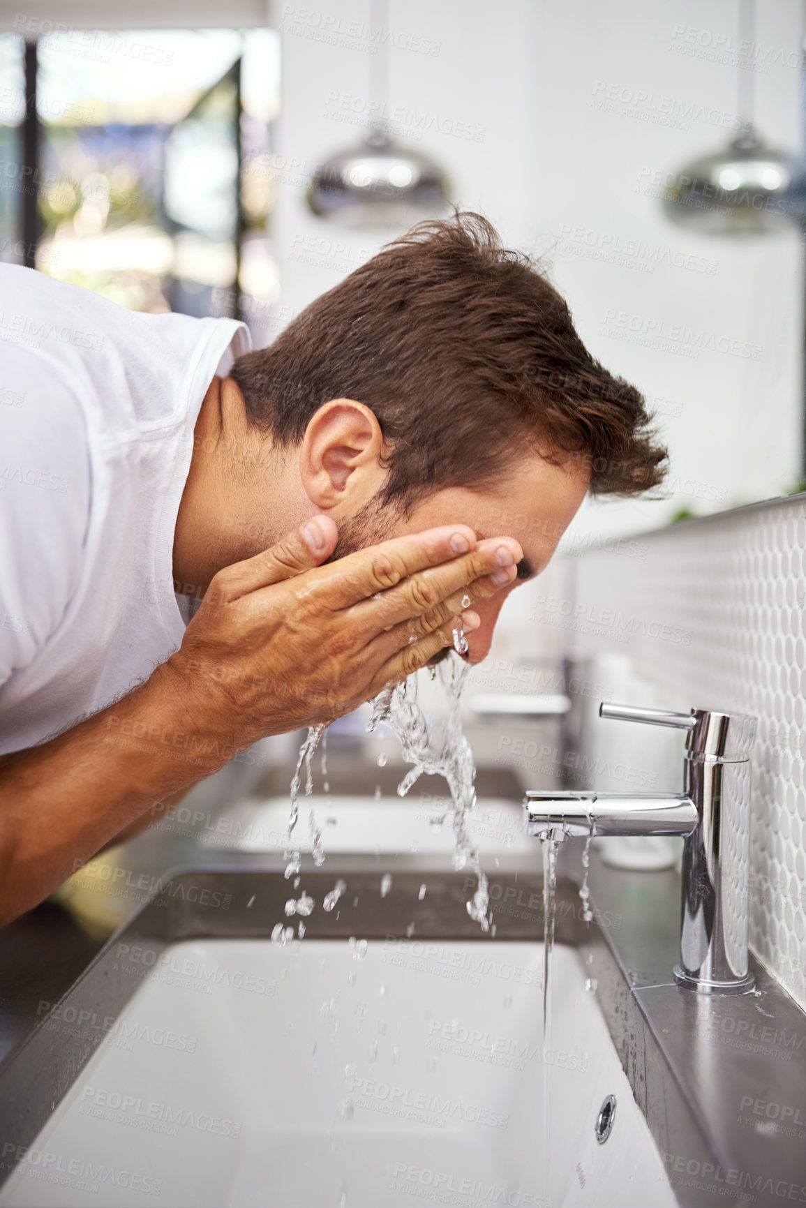 Buy stock photo Cropped close up shot of a handsome man splashing his face with water in the bathroom at home