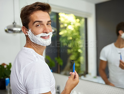 Buy stock photo Cropped shot of a handsome man about to shave his beard in the bathroom at home