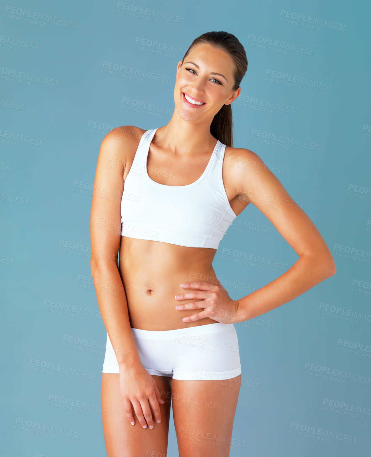 Buy stock photo Studio portrait of a fit young woman posing against a blue background