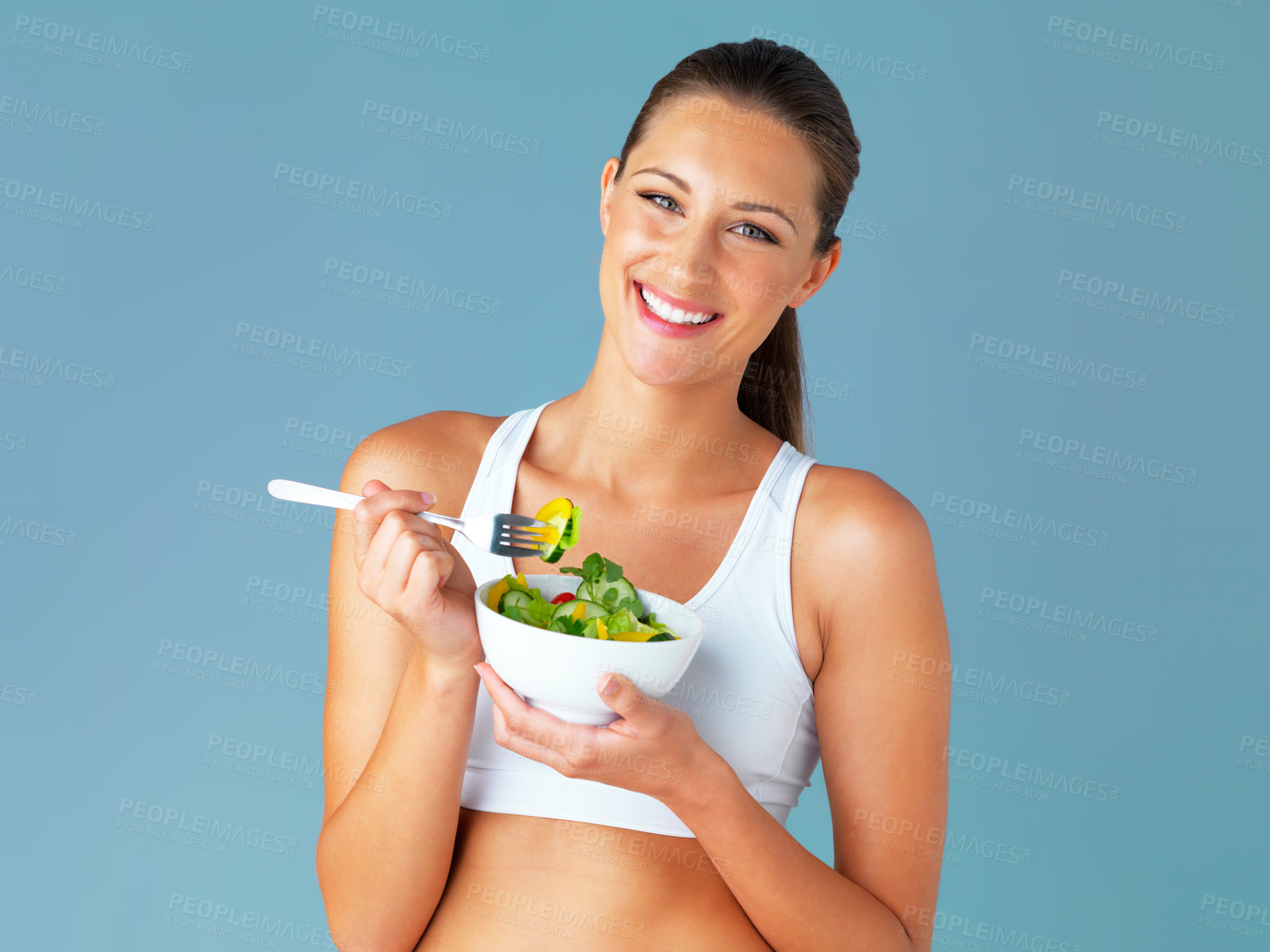 Buy stock photo Woman, portrait and happy, salad and vegetable for health and nutritionist in isolated blue background. Face, vegan and wellness, diet with female model in studio and tasting organic food in bowl