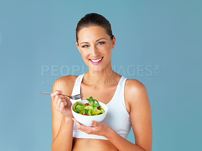 Buy stock photo Woman in portrait, smile and eating salad, diet and healthy food with weight loss isolated on blue background. Health, wellness and nutrition with vegetables, female model in studio and mockup space