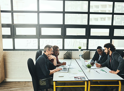Buy stock photo Cropped shot of a group of designers working at a desk in their office