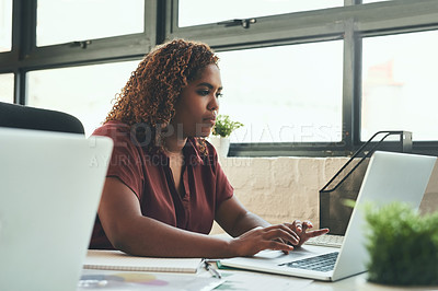 Buy stock photo Cropped shot of a young businesswoman working on her laptop in the office