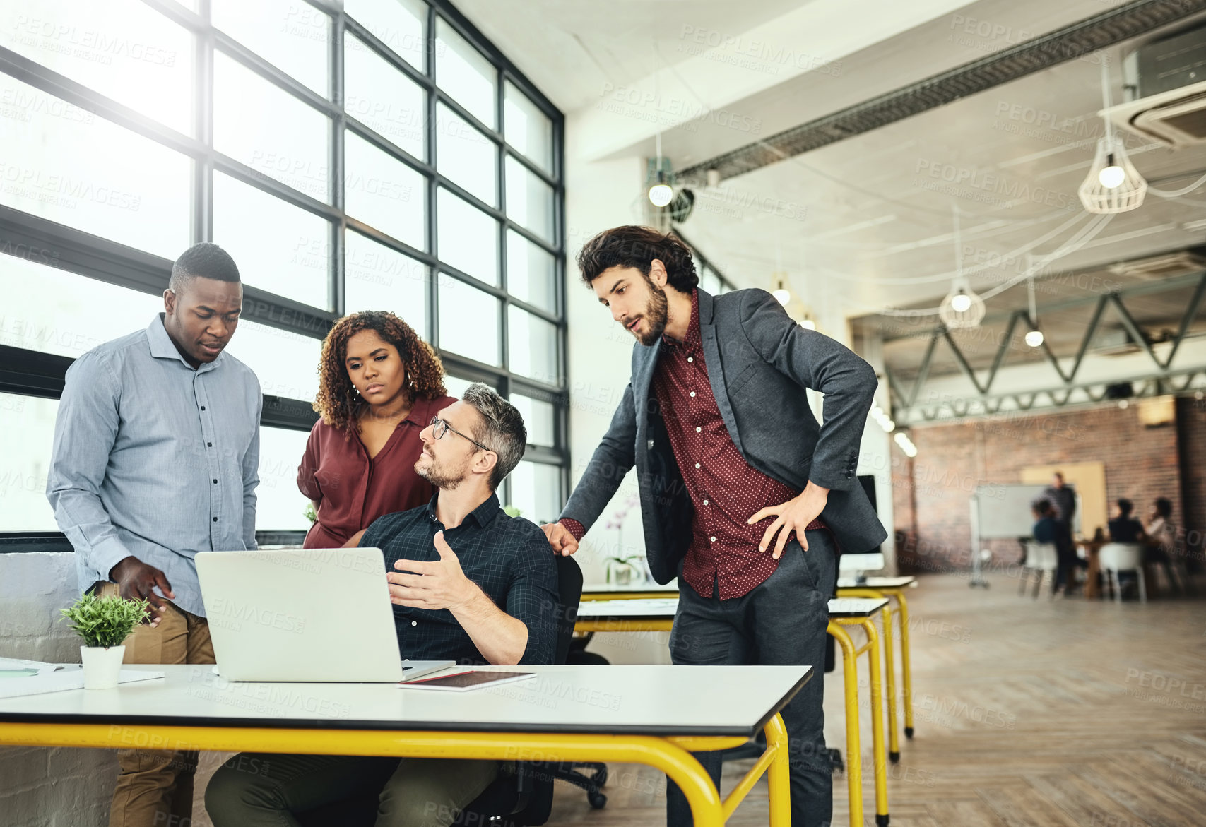 Buy stock photo Cropped shot of a group of businesspeople working together around a laptop in the office