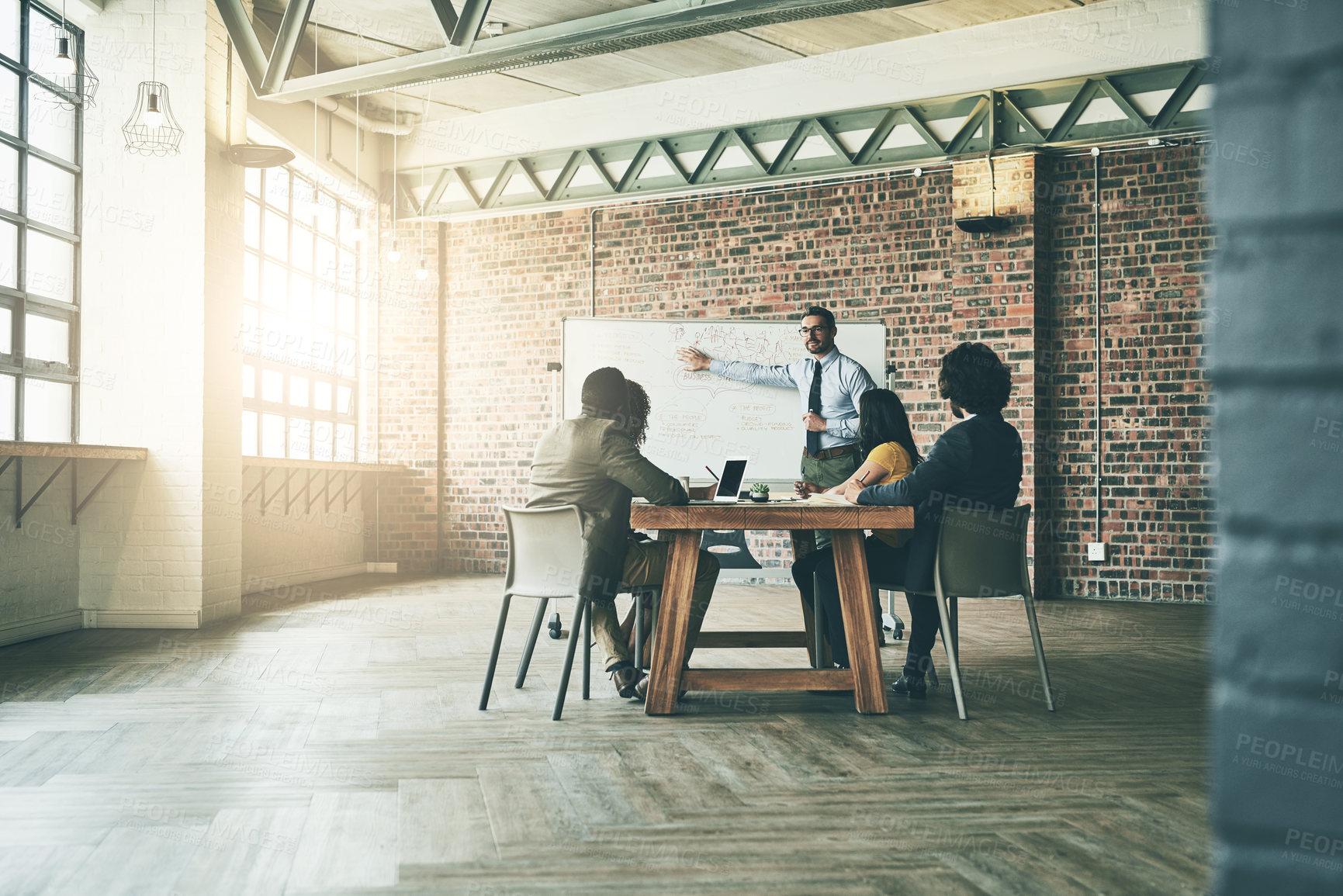 Buy stock photo Shot of a well-dressed businessman giving a presentation to his colleagues in the office