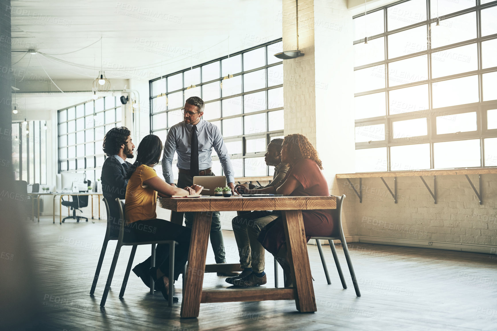 Buy stock photo Shot of a well-dressed businessman presenting a new idea to his colleagues in the office