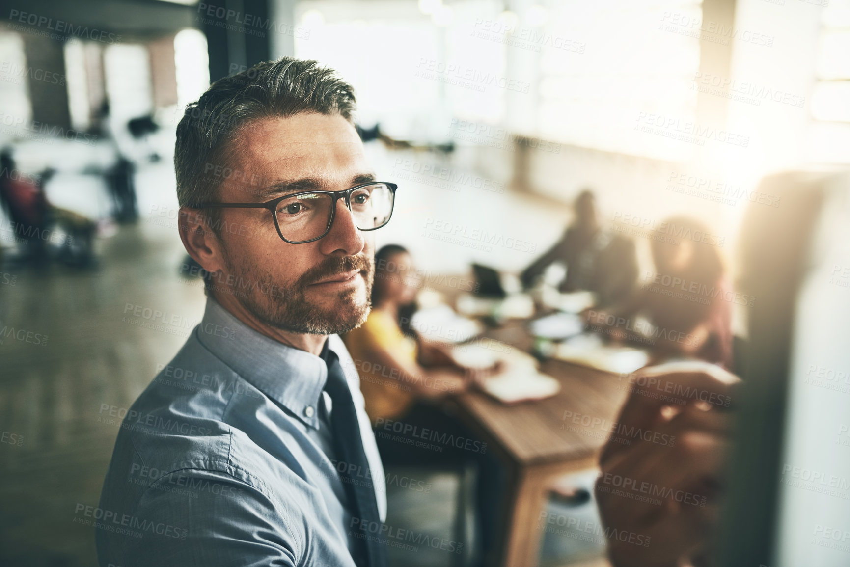 Buy stock photo Shot of a well-dressed businessman giving a presentation to his colleagues in the office