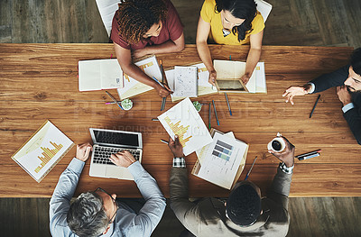 Buy stock photo High angle shot of a team of businesspeople meeting around the boardroom table in the office