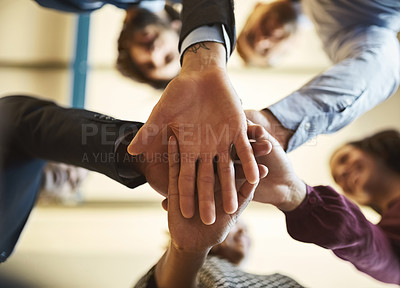 Buy stock photo Low angle shot of a team of businesspeople piling their hands on top of each other in the office
