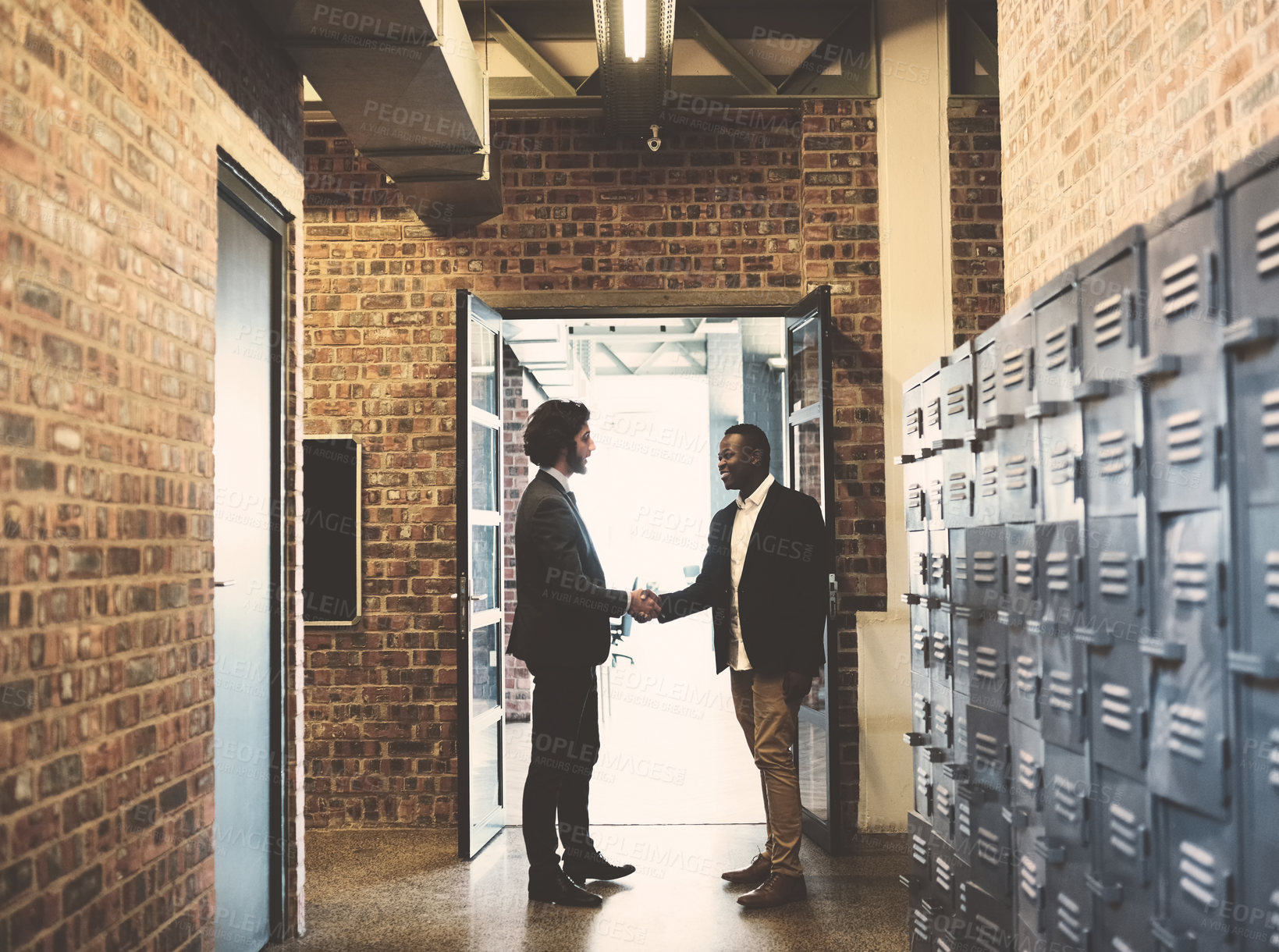 Buy stock photo Shot of two professional businessmen shaking hands outside their office