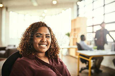 Buy stock photo Cropped portrait of an attractive young businesswoman sitting in the office with her colleagues in the background