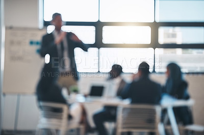 Buy stock photo Defocussed shot of a team of businesspeople attending a presentation in the boardroom