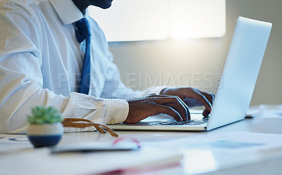 Buy stock photo Shot of an unrecognisable businessman working on a laptop in an office