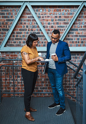 Buy stock photo Shot of two young designers having a discussion in an office