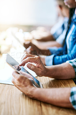 Buy stock photo Cropped shot of businesspeople using digital tablets while sitting in a meeting