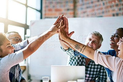 Buy stock photo Shot of a team of motivated creatives giving each other a high five