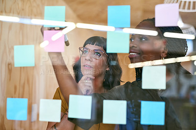 Buy stock photo Business people, thinking and planning with notes in a creative office for designer project. Women team together for collaboration, teamwork and ideas on a glass wall with color paper and diversity