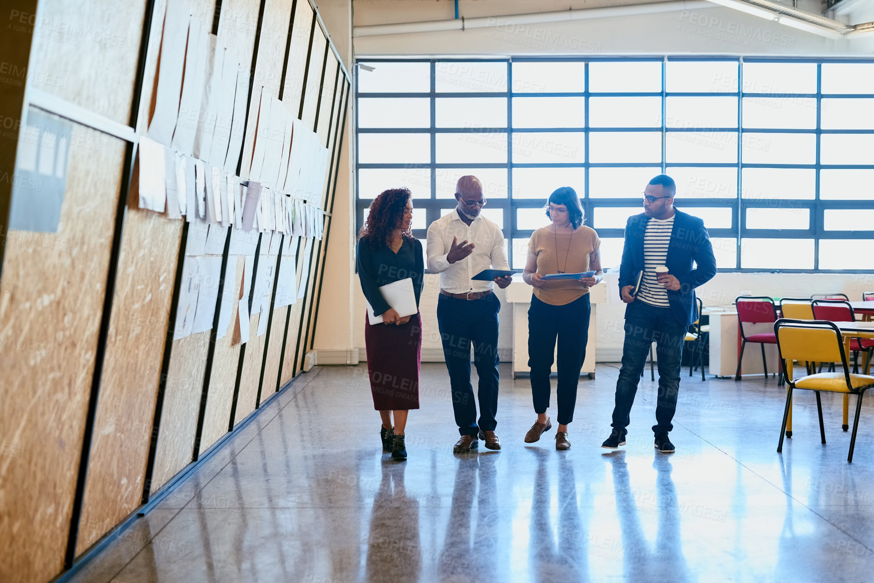 Buy stock photo Shot of a group of designers having a discussion while walking through a office