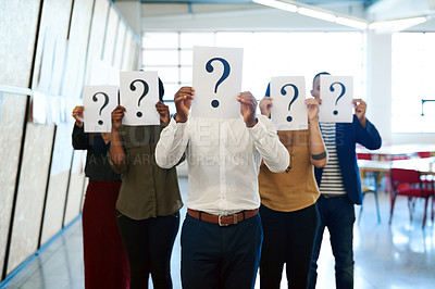 Buy stock photo Shot of a group of businesspeople holding up placards with question marks on it