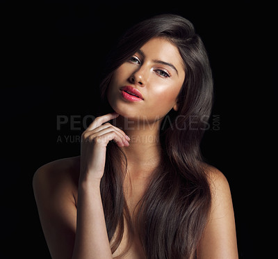 Buy stock photo Studio shot of a beautiful woman touching her chin posing against a black background