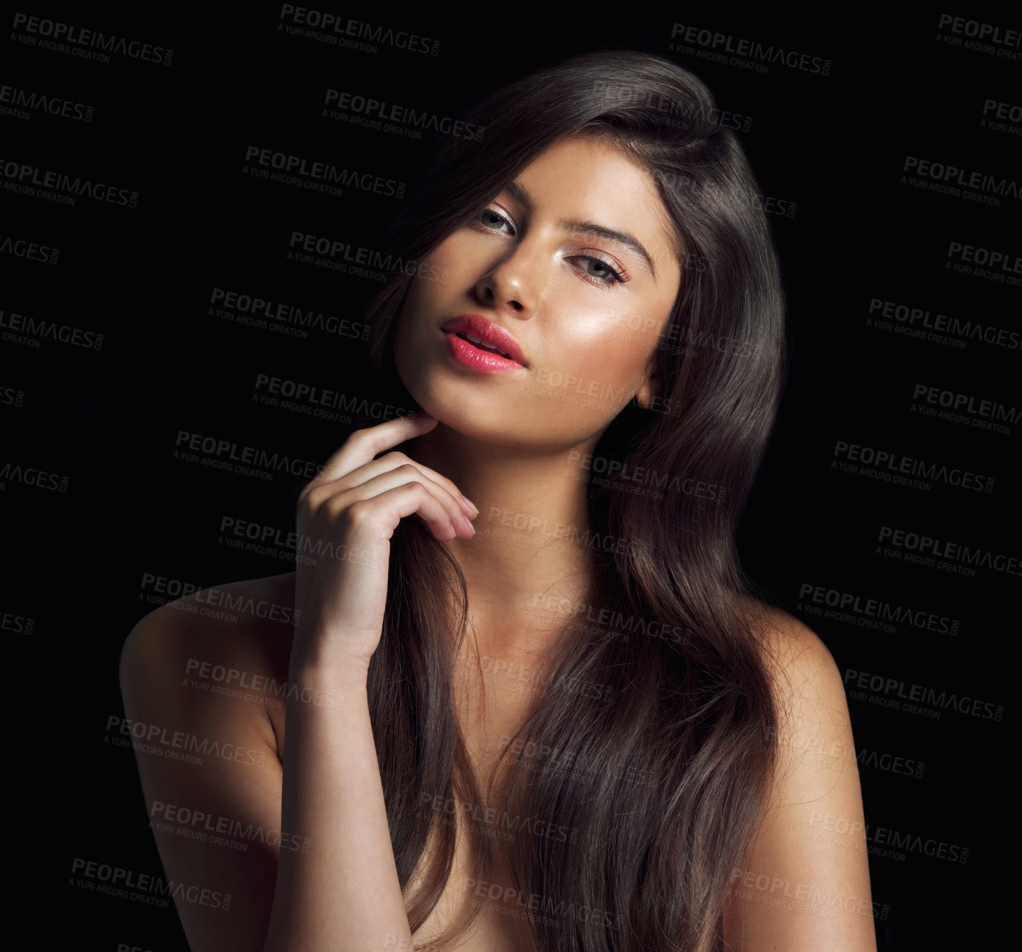 Buy stock photo Studio shot of a beautiful woman touching her chin posing against a black background