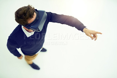 Buy stock photo High angle shot of a businessman wearing a VR headset while connecting to a user interface in an office
