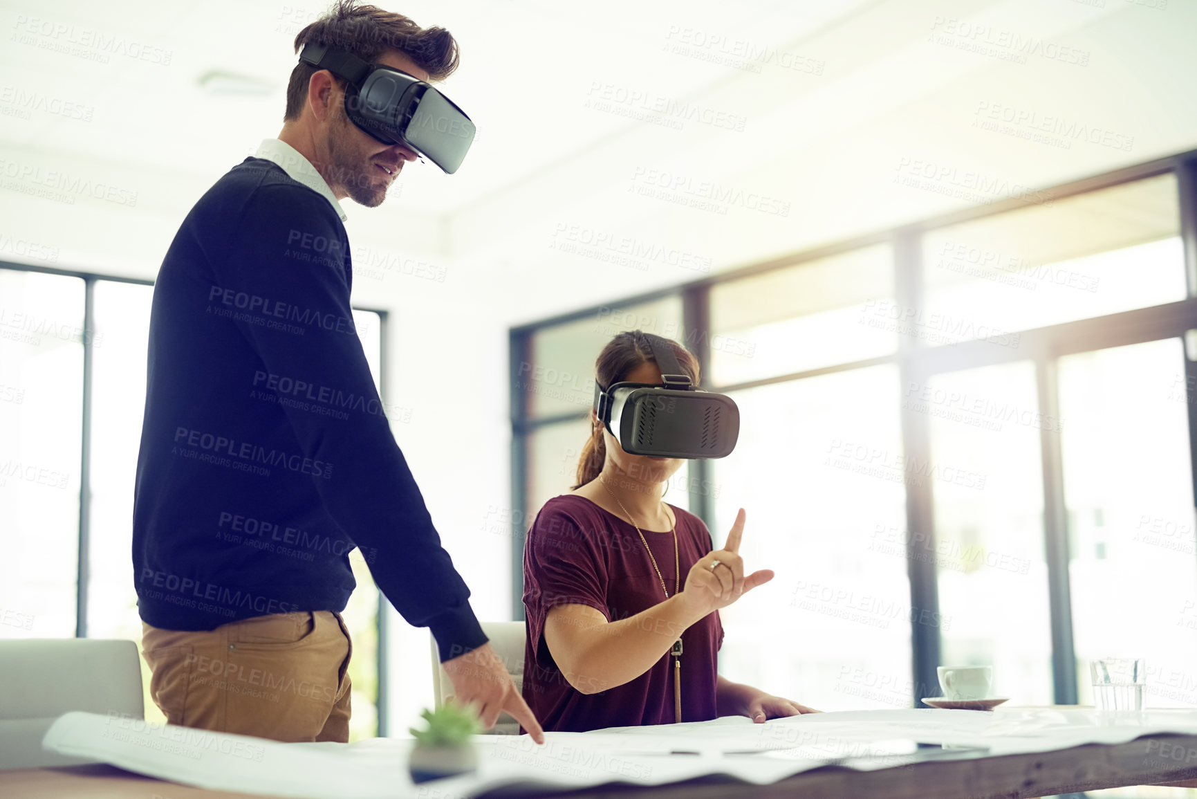 Buy stock photo Shot of two businesspeople wearing VR headsets while working together in an office